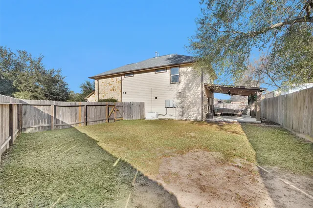 a view of backyard with wooden fence