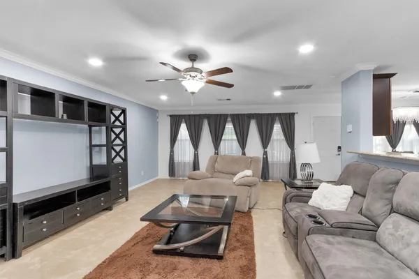 a living room with furniture a flat screen tv and a large window