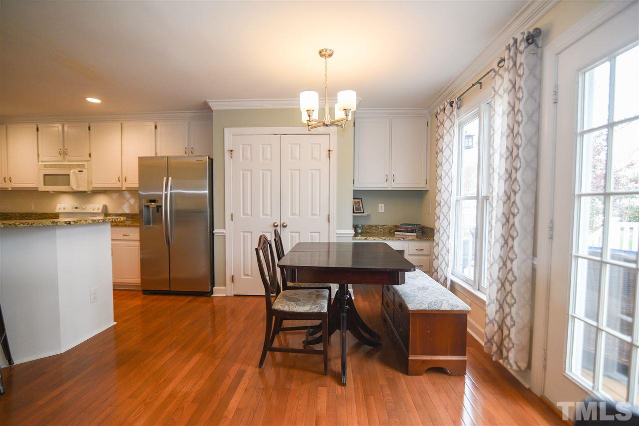 9200 Dawnshire Road Raleigh, NC 27615 - Photo 13 of 30 a kitchen with stainless steel appliances granite countertop a dining table chairs refrigerator sink and cabinets