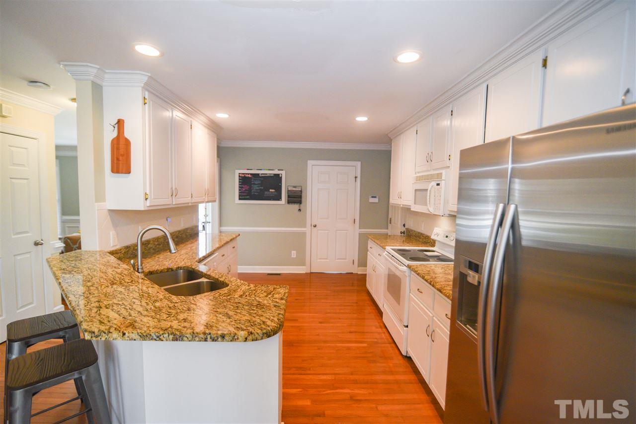 9200 Dawnshire Road Raleigh, NC 27615 - Photo 9 of 30 a large kitchen with granite countertop a sink refrigerator and cabinets