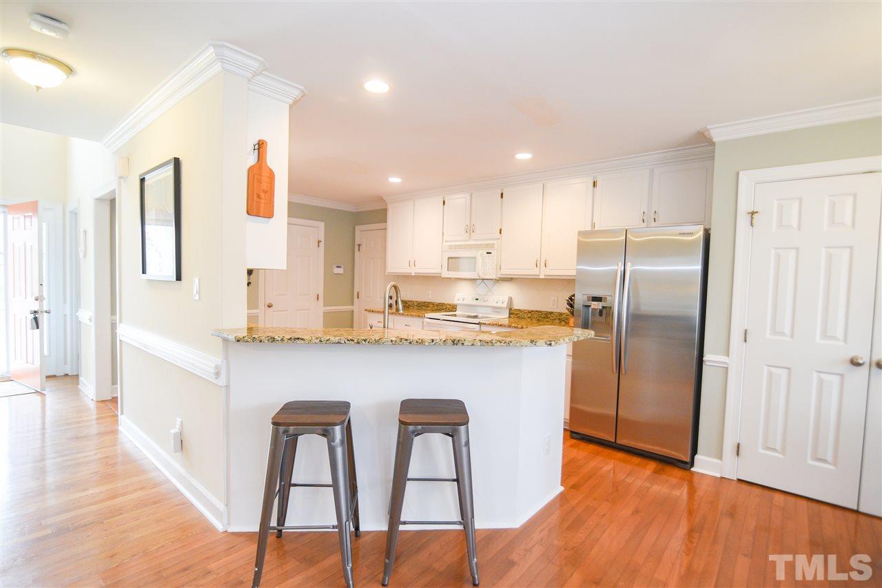 9200 Dawnshire Road Raleigh, NC 27615 - Photo 10 of 30 a kitchen with stainless steel appliances granite countertop a refrigerator a microwave a stove and white cabinets with wooden floor