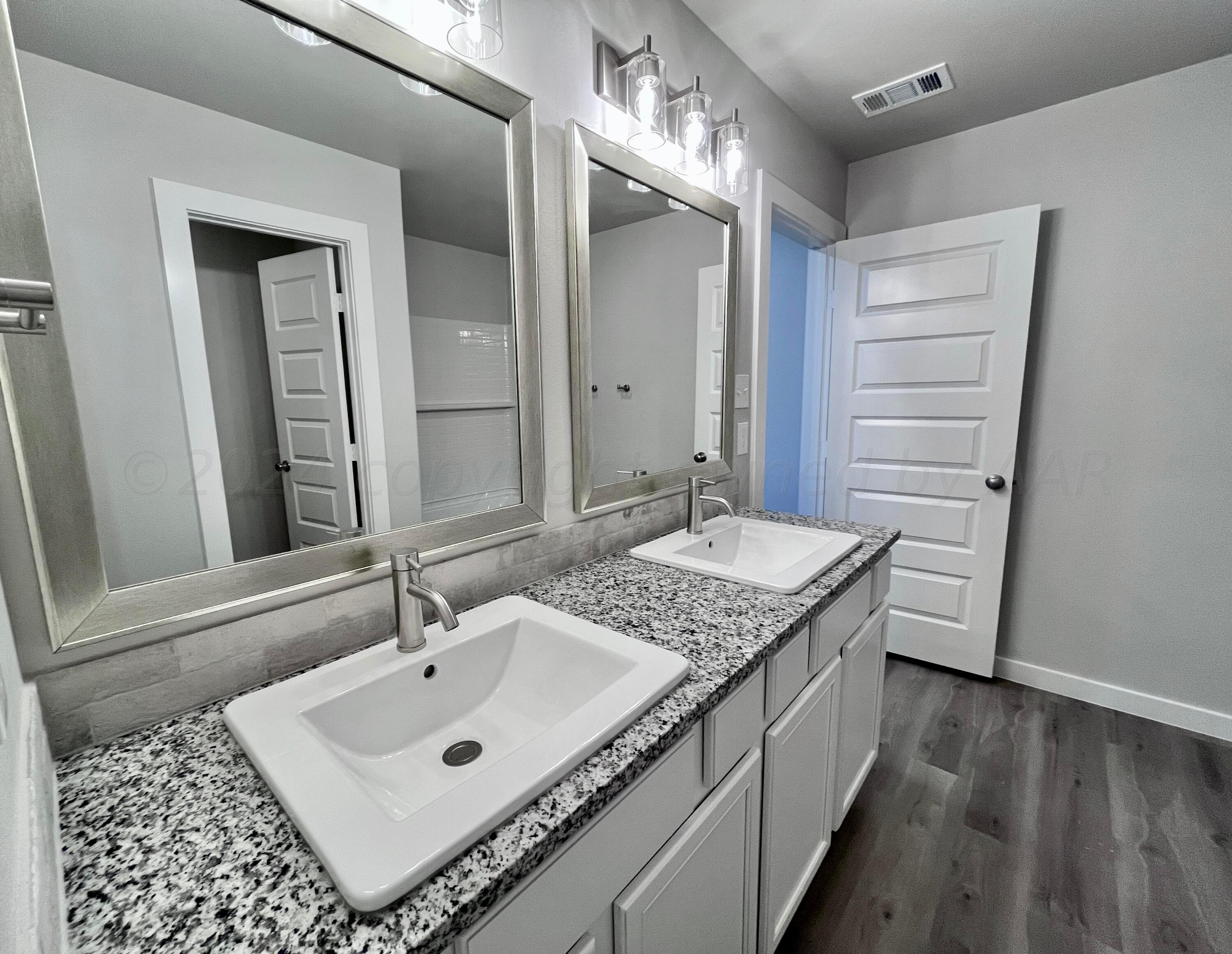 3103 Swenson Street Amarillo, TX 79124 - Photo 12 of 23 a bathroom with a sink a vanity and a mirror