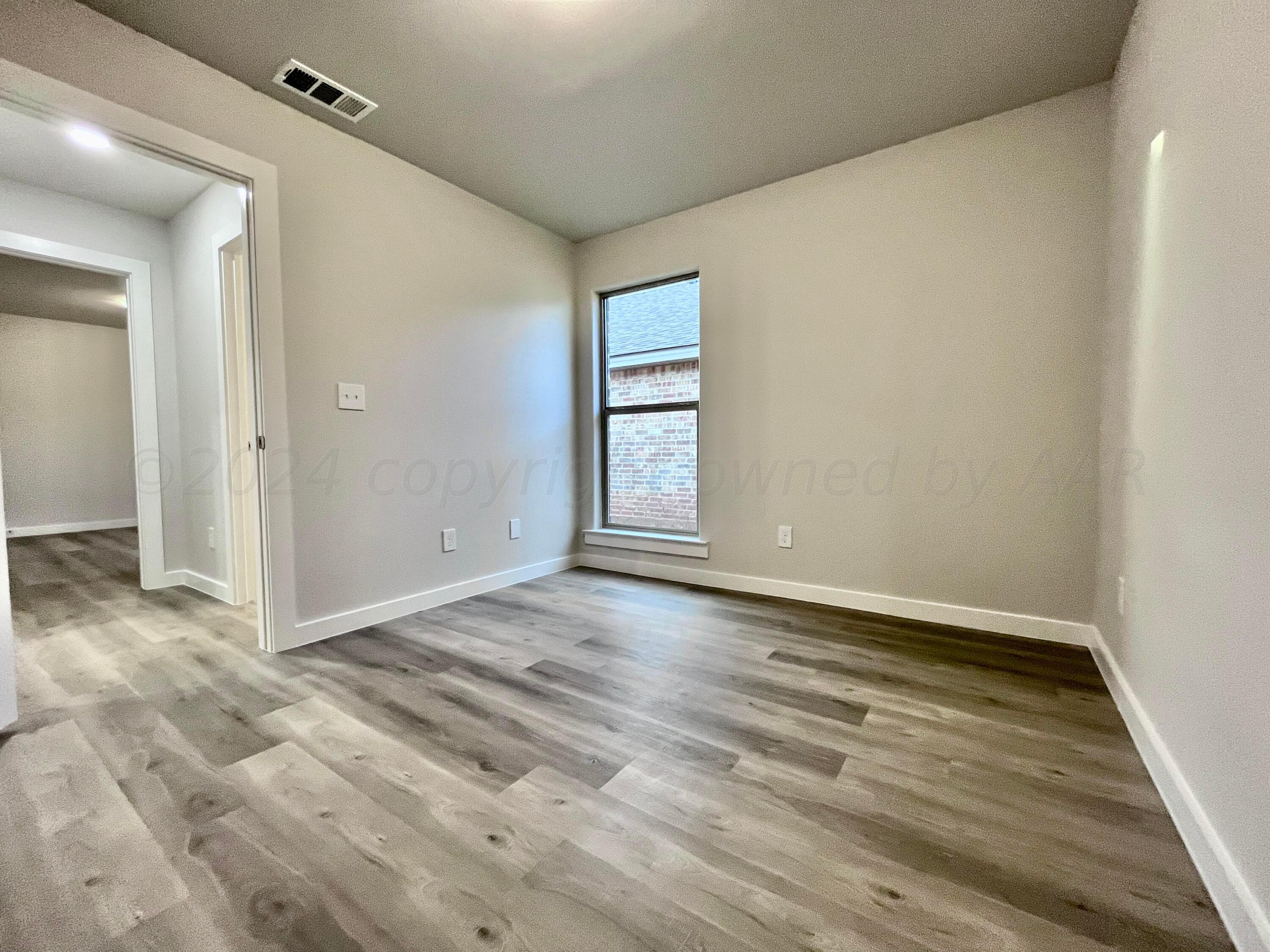 3103 Swenson Street Amarillo, TX 79124 - Photo 16 of 23 a view of an empty room with wooden floor and a window