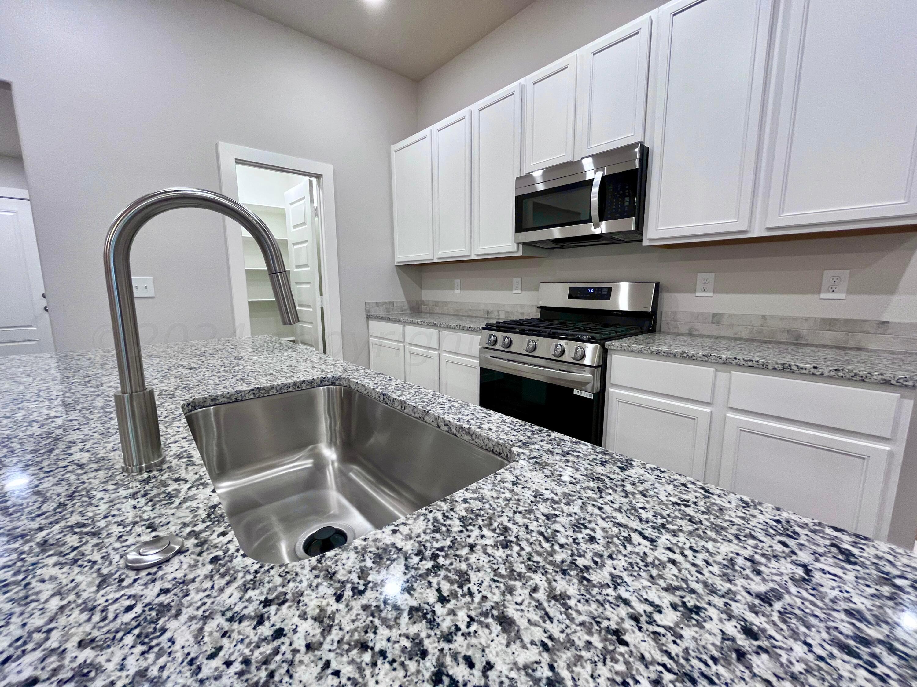 3103 Swenson Street Amarillo, TX 79124 - Photo 2 of 23 a kitchen with a stove top oven and cabinets