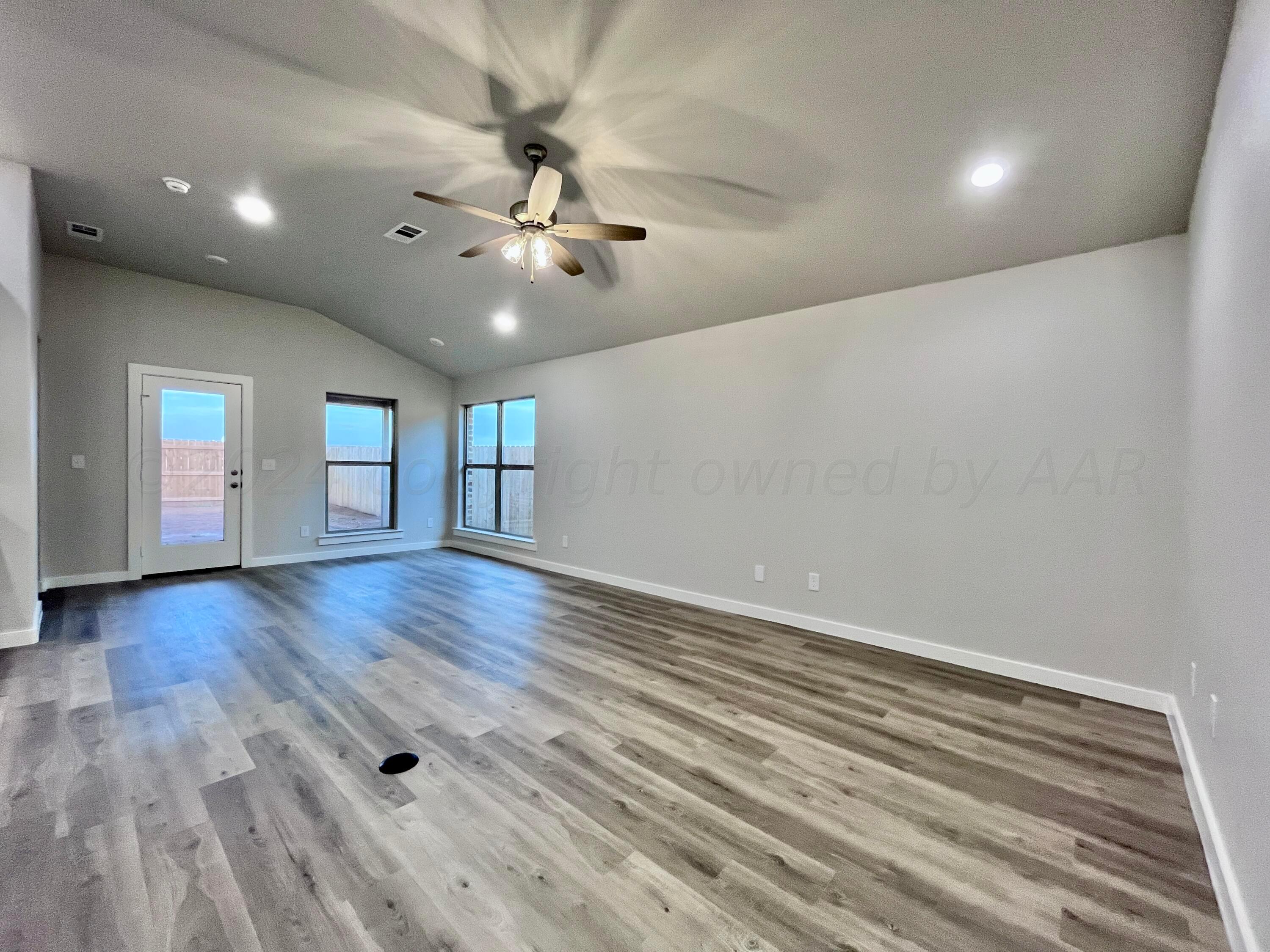 3103 Swenson Street Amarillo, TX 79124 - Photo 3 of 23 wooden floor in an empty room with a window