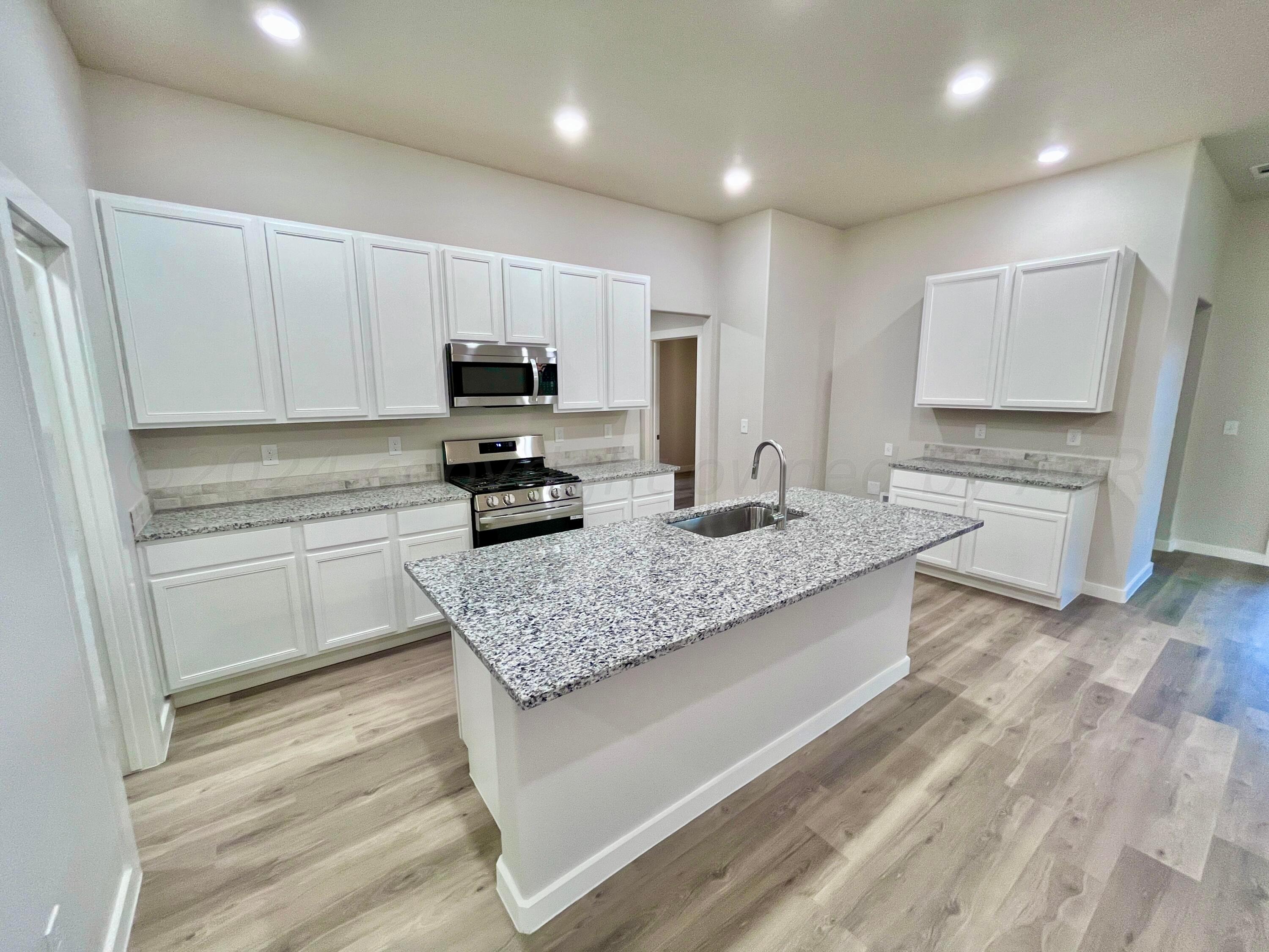 3103 Swenson Street Amarillo, TX 79124 - Photo 5 of 23 a kitchen with granite countertop a sink stove and cabinets