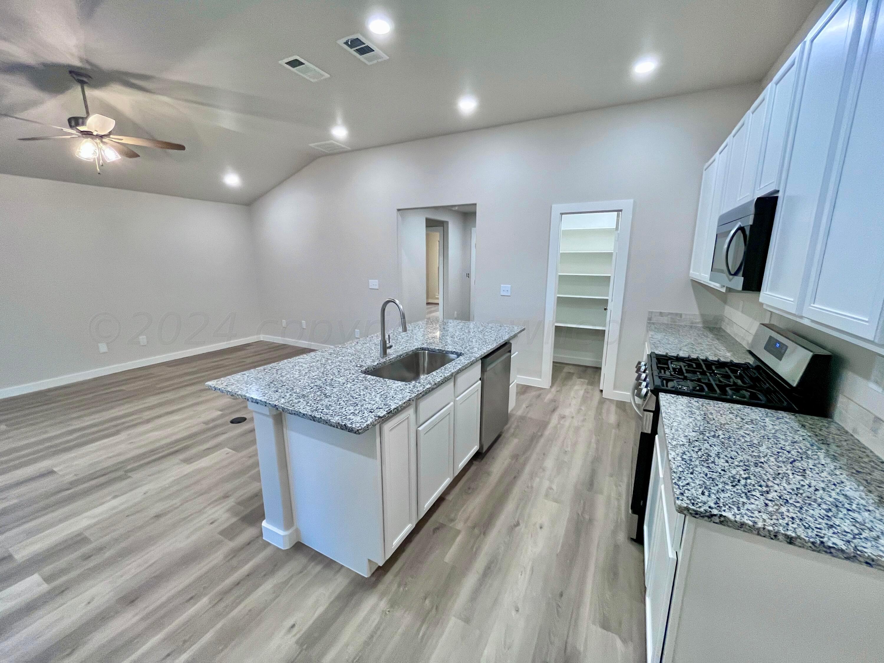 3103 Swenson Street Amarillo, TX 79124 - Photo 7 of 23 a kitchen with a stove and a sink