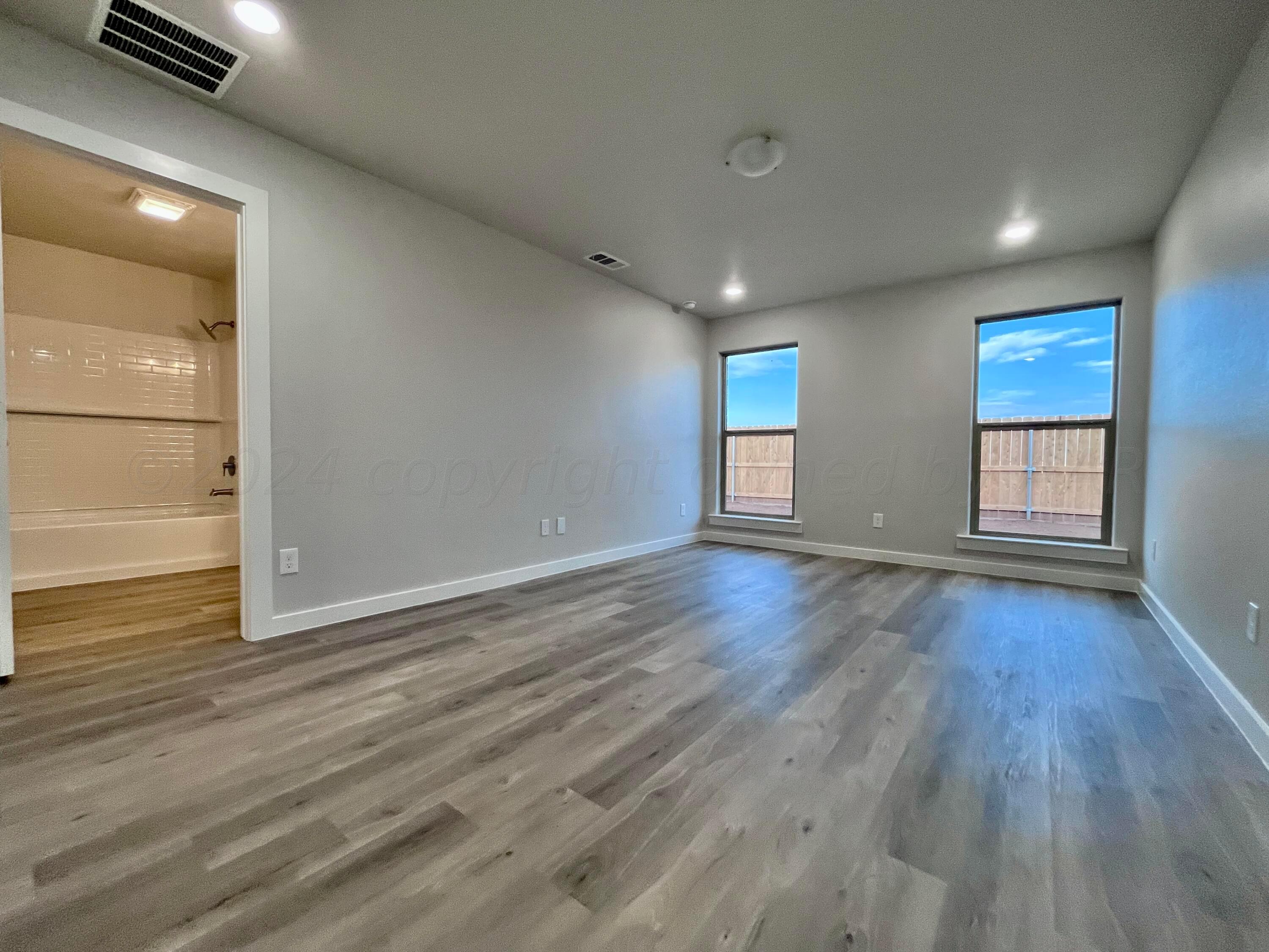 3103 Swenson Street Amarillo, TX 79124 - Photo 9 of 23 an empty room with wooden floor and windows