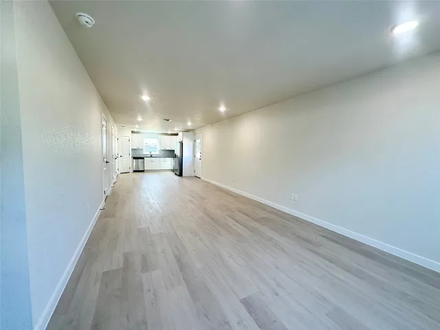 a view of a kitchen with a sink and wooden floor