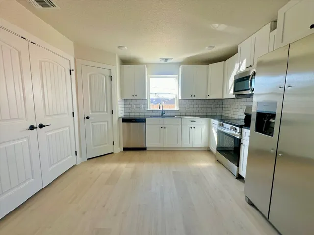 a kitchen with stainless steel appliances granite countertop a refrigerator oven a sink and dishwasher