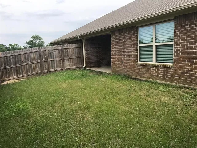 a view of a backyard with a garden and entertaining space