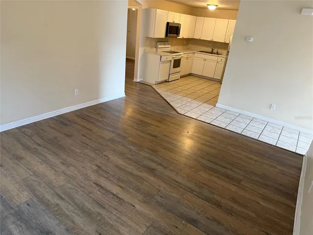a kitchen with a wooden floor and white appliances
