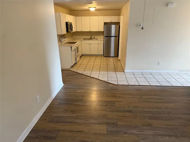 a kitchen with kitchen island granite countertop a sink cabinets and stainless steel appliances