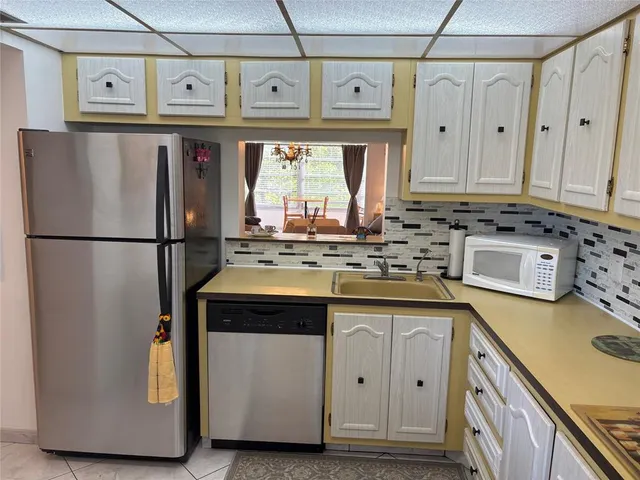 a kitchen with stainless steel appliances granite countertop a sink and a refrigerator