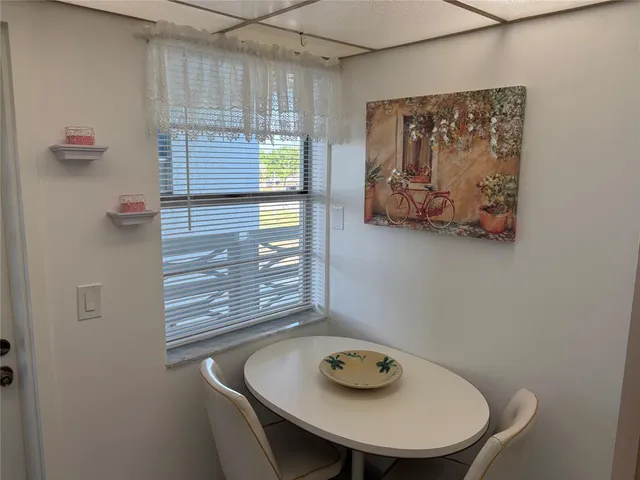 a bathroom with a granite countertop sink a window and a shower