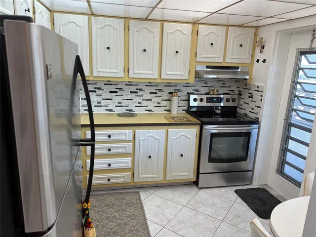 a kitchen with stainless steel appliances a stove a refrigerator and cabinets