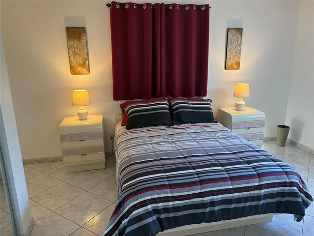 a bedroom with a bed and a lamp with the wooden floor