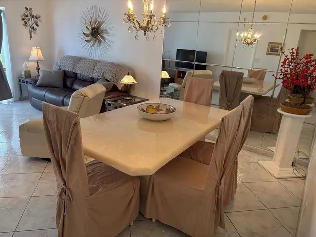 a view of a dining room with furniture and chandelier
