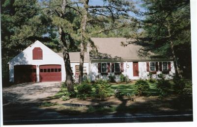 a front view of house with yard and trees around