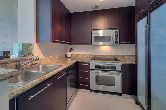 a kitchen with stainless steel appliances granite countertop a sink stove and microwave