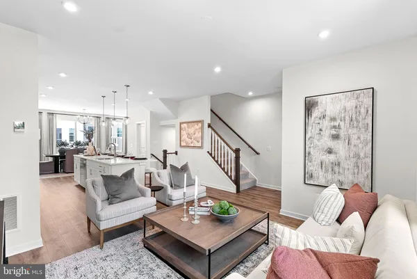 a living room with furniture and a view of kitchen