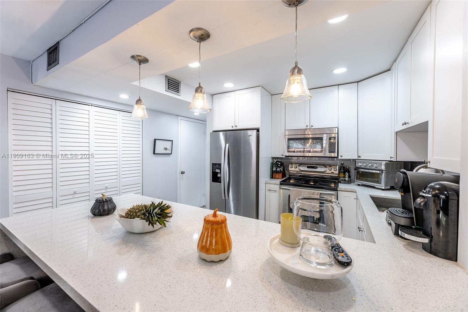 10037 Southwest 77th Court Miami, FL 33156 - Photo 16 of 70 a kitchen with sink refrigerator and microwave
