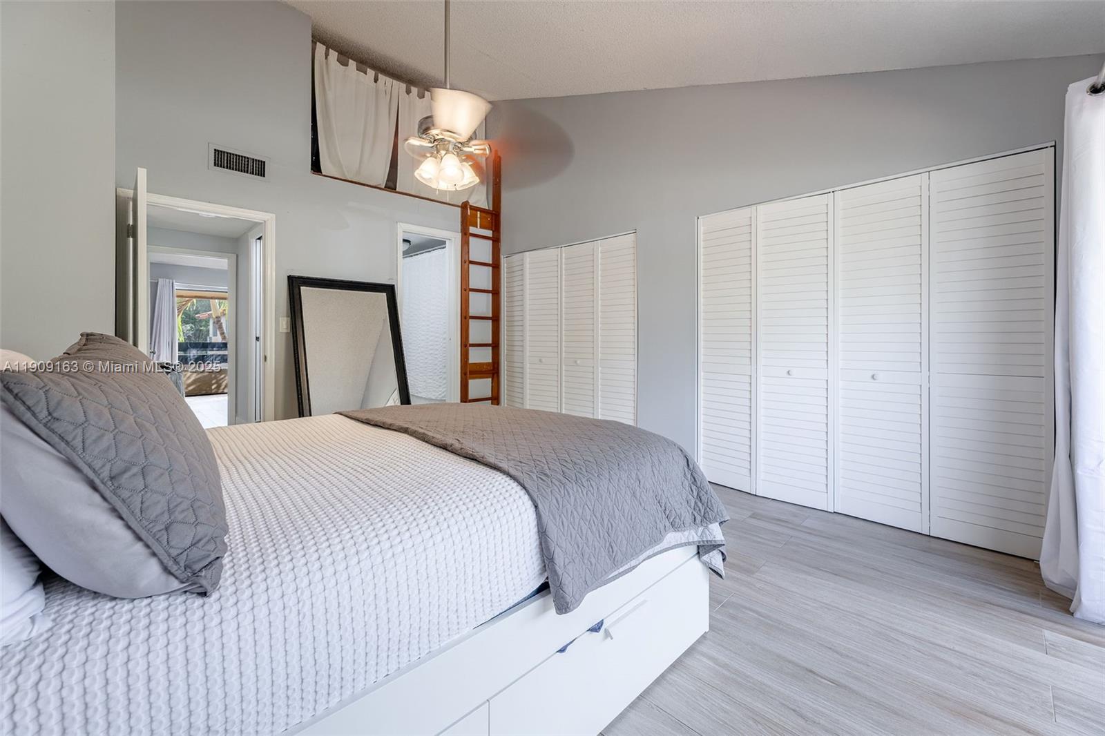 10037 Southwest 77th Court Miami, FL 33156 - Photo 31 of 70 a bedroom with a bed and a chandelier