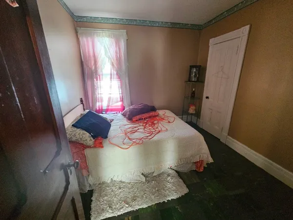 a bed sitting in a bedroom next to a window
