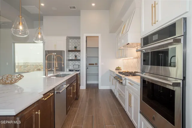 a kitchen with stainless steel appliances granite countertop a stove and a refrigerator