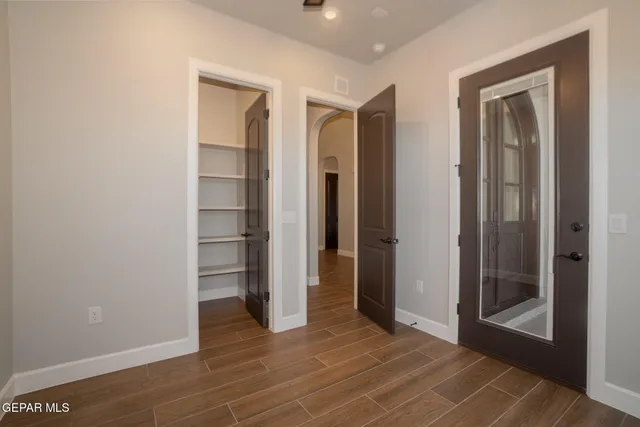 a view of an empty room with wooden floor