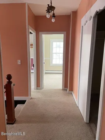 a view of a livingroom with a chandelier fan and windows