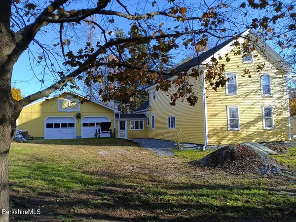 a view of a house with a big yard and large trees