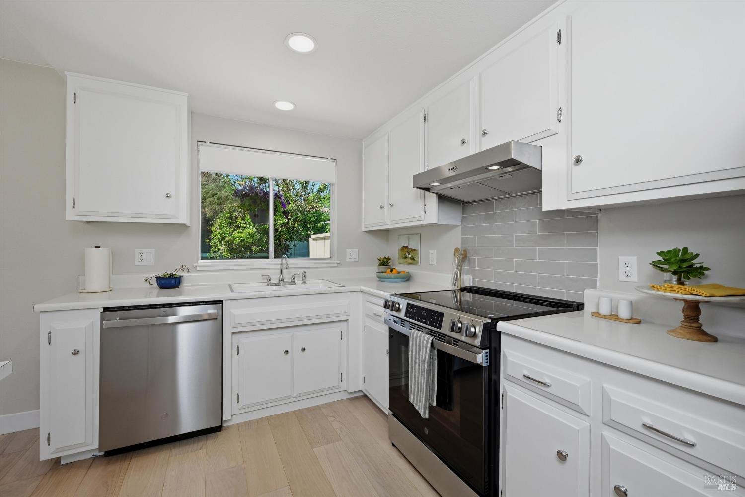 23 Valley Green Street Santa Rosa, CA 95409 - Photo 9 of 58 a kitchen with stainless steel appliances granite countertop white cabinets a sink a stove a window and white cabinets