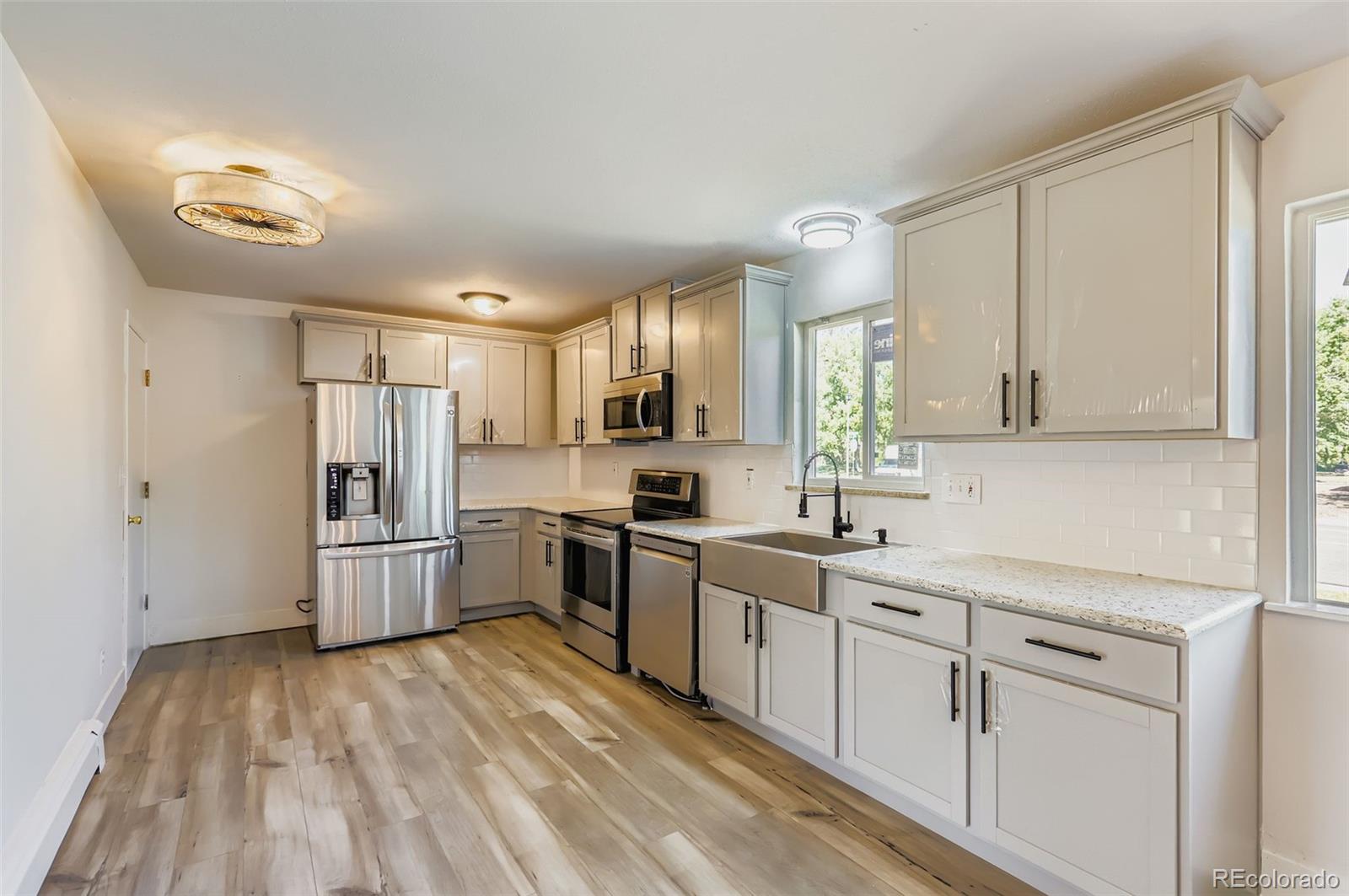 2412 West 20th Street Greeley, CO 80634 - Photo 4 of 23 a kitchen with white cabinets and white appliances