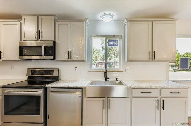 a kitchen with stainless steel appliances granite countertop a sink stove and microwave