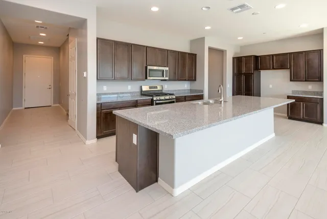 a kitchen with stainless steel appliances granite countertop a refrigerator stove top oven a sink and dishwasher