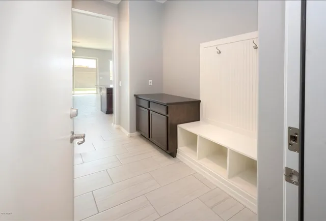 a kitchen with a refrigerator and white cabinets