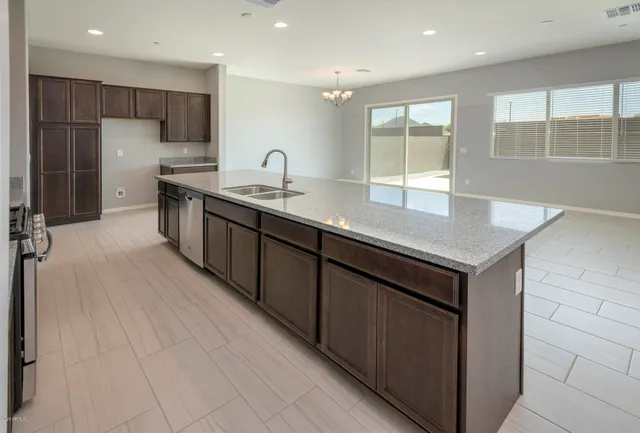 a kitchen with stainless steel appliances granite countertop a stove a sink and a microwave