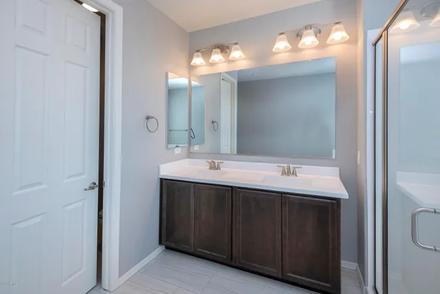 a spacious bathroom with a tub sink shower and mirror