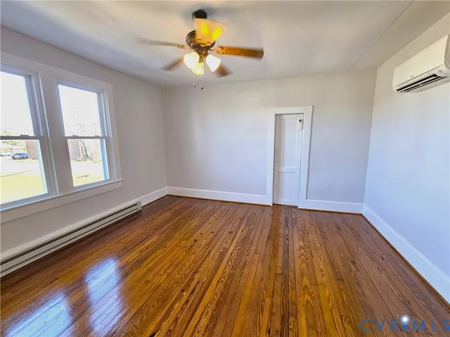 an empty room with wooden floor and window