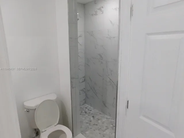 a bathroom with a toilet and a shower