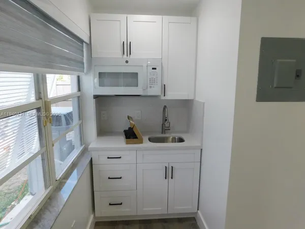a view of cabinets a sink and a stove in a kitchen