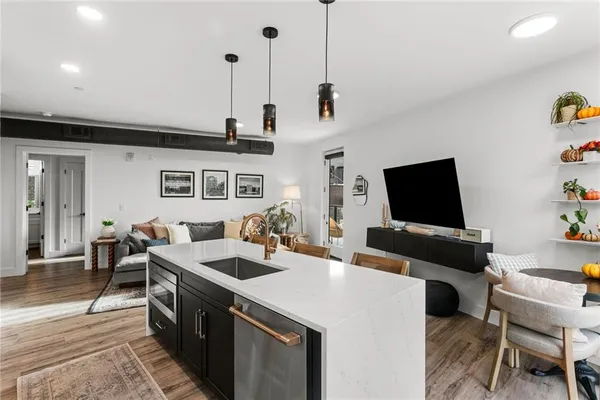 a kitchen with stainless steel appliances kitchen island granite countertop a sink and wooden floors