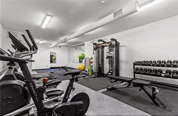 a large bedroom with a bed and a wooden floor