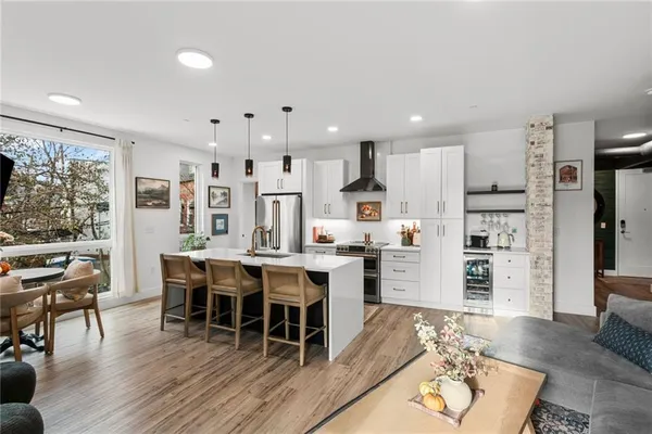 a kitchen with stainless steel appliances kitchen island granite countertop a table chairs and a refrigerator