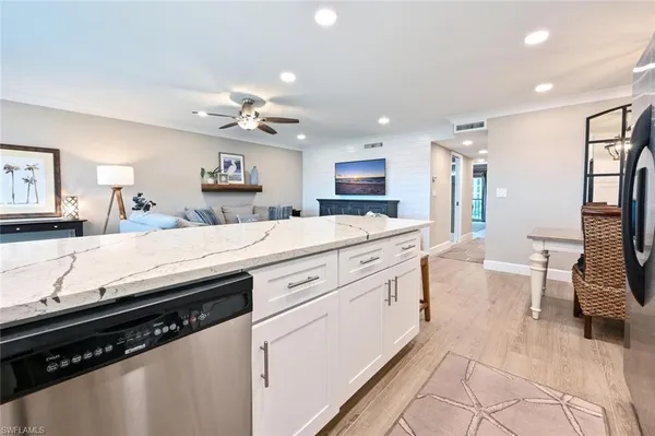 a kitchen with stainless steel appliances kitchen island granite countertop a sink and cabinets