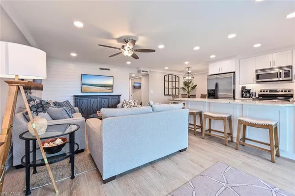 a living room with stainless steel appliances kitchen island granite countertop furniture and a view of kitchen