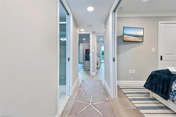 a view of a hallway with a livingroom and a bathroom