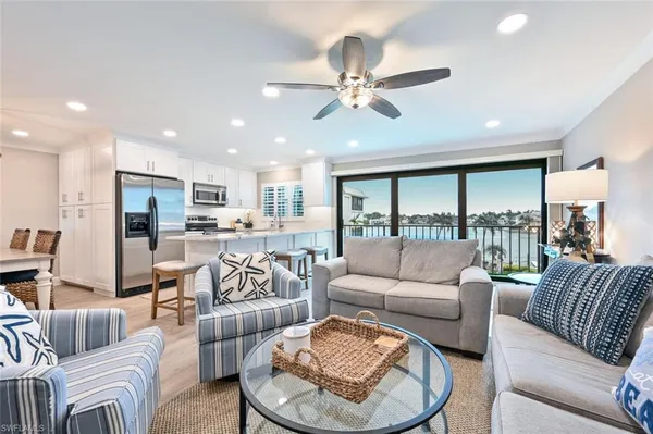 a living room with furniture kitchen and a large window