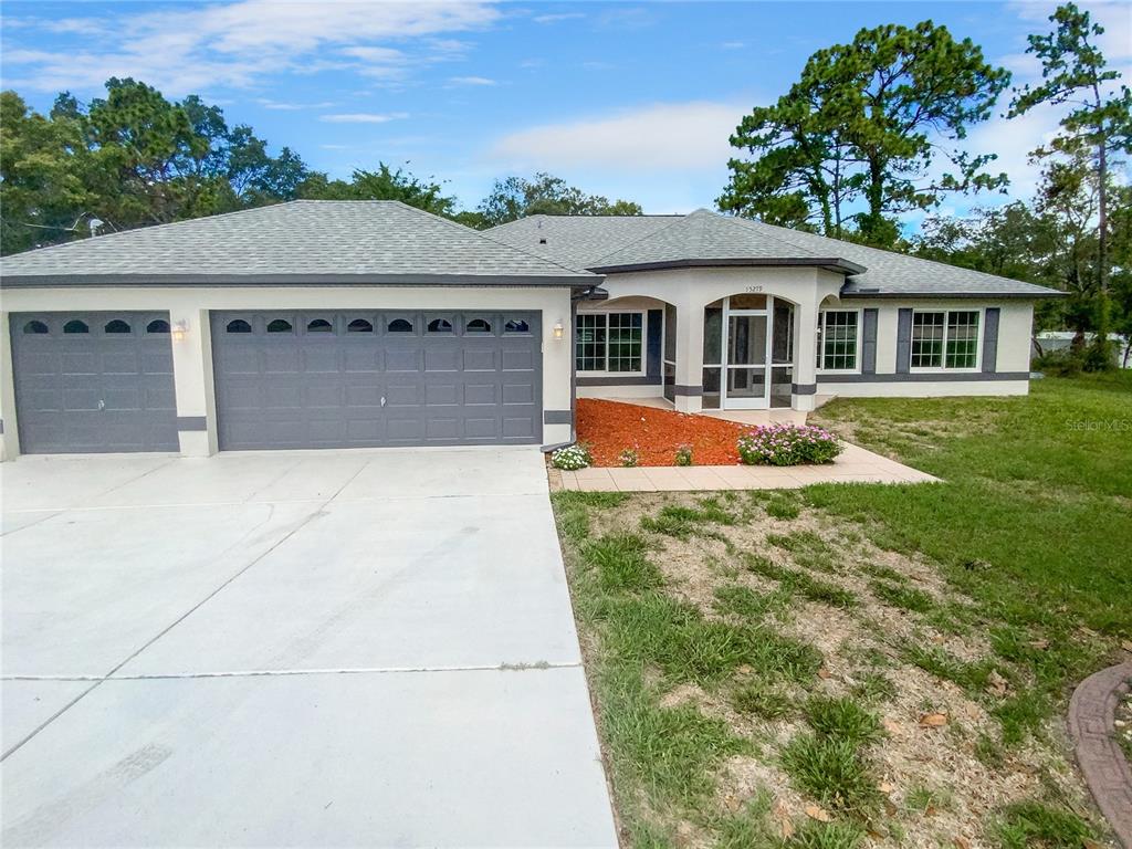 15279 Mt Sparrow Road Weeki Wachee, FL 34614 - Photo 1 of 1 a front view of a house with a yard table and chairs